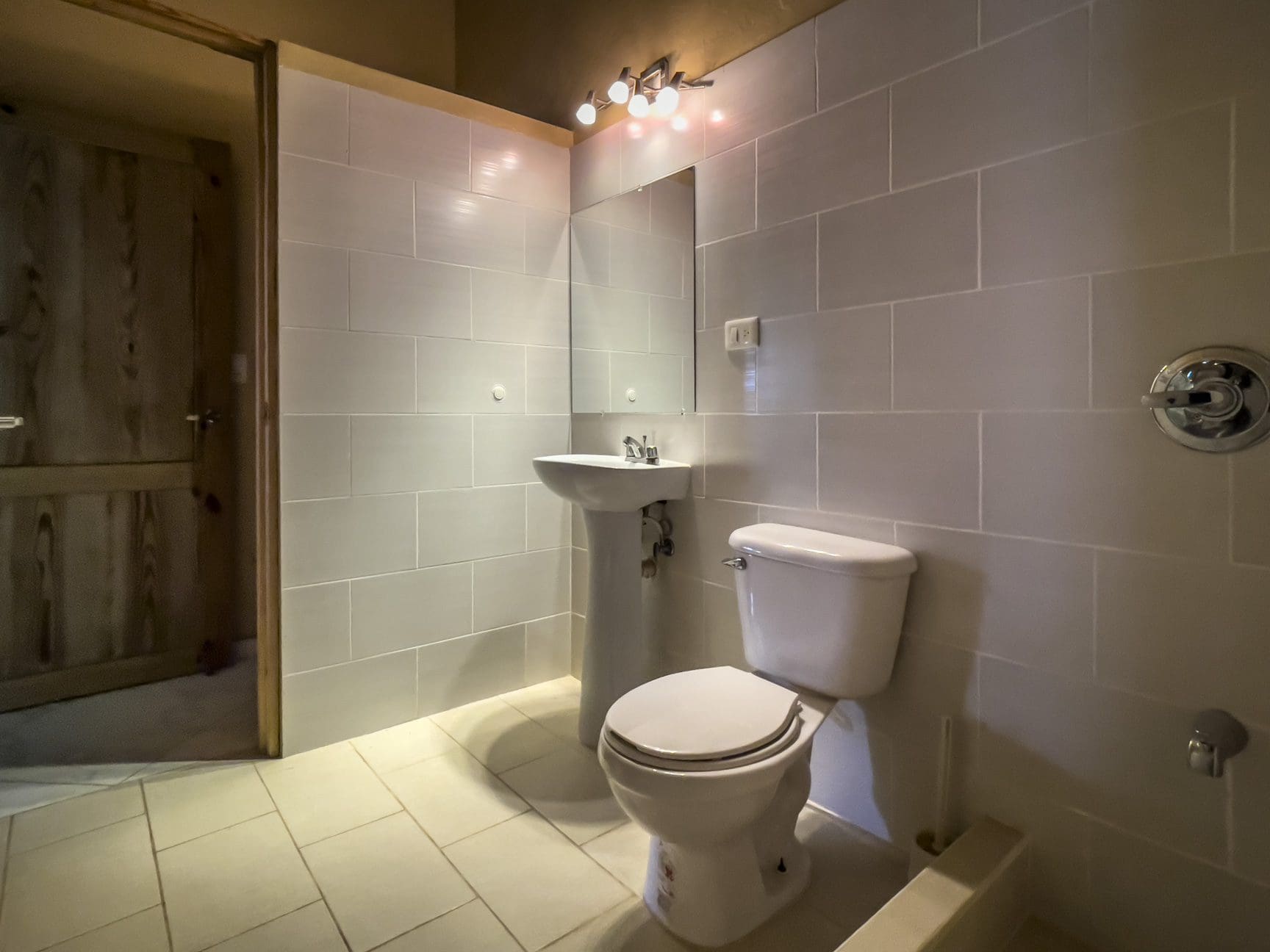 buyDRproperty Bathroom with white tiled walls, sink, and toilet. For Sale 3 Bedroom Villa. Sosua Real Estate