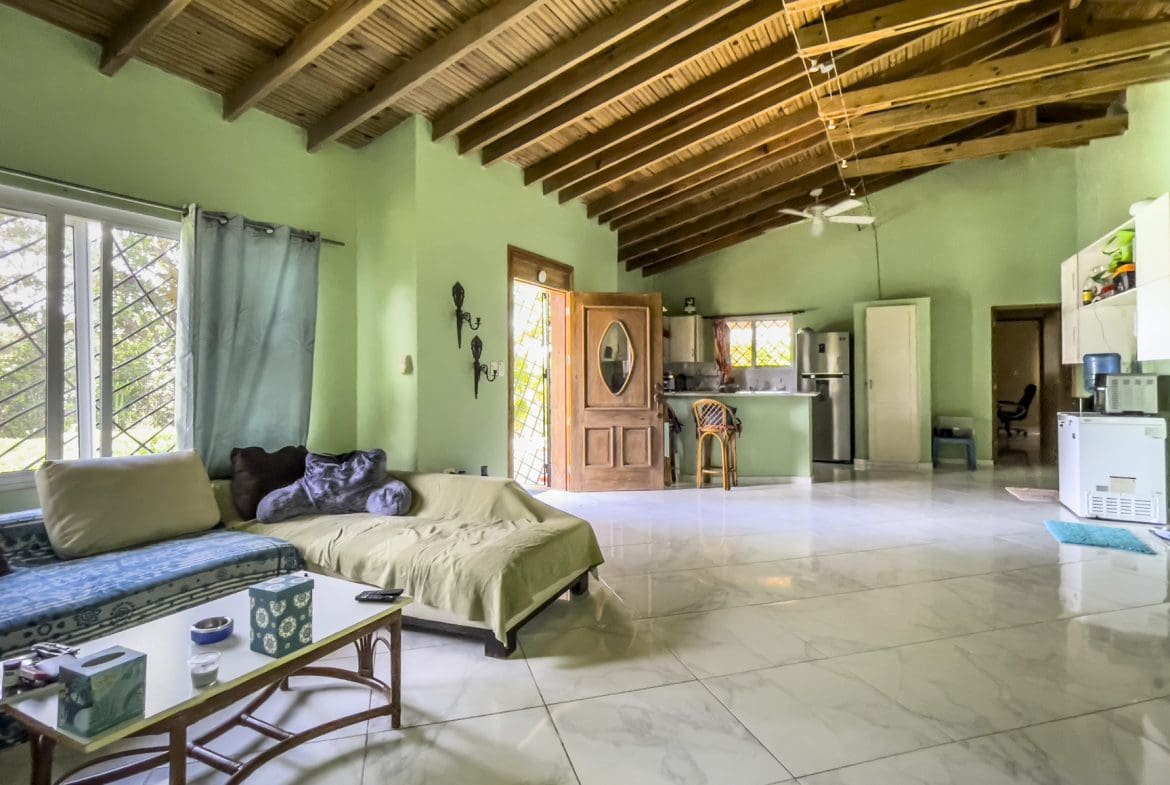 buyDRproperty Living room of a 3 bedroom villa for sale with wooden ceiling and open kitchen. Sosua Real Estate
