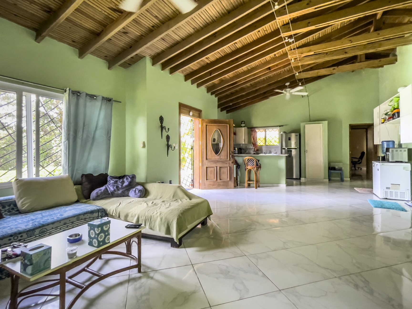 buyDRproperty Living room of a 3 bedroom villa for sale with wooden ceiling and open kitchen. Sosua Real Estate