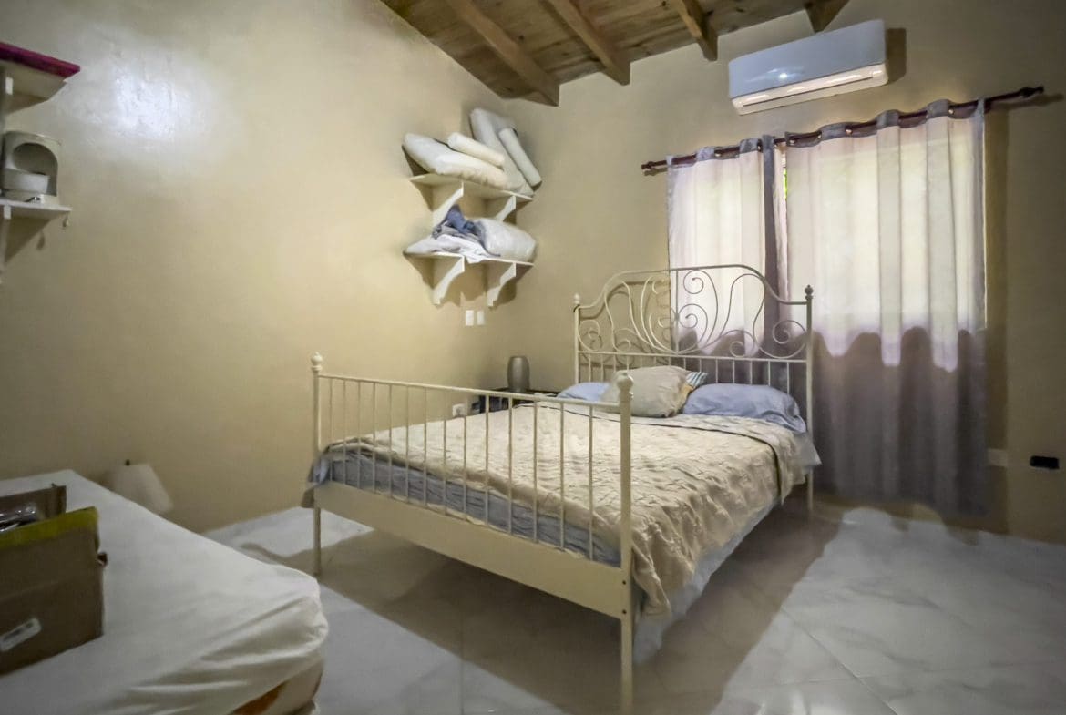buyDRproperty Bedroom in a For Sale 3 Bedroom Villa with white metal bed frame and window Sosua Real Estate