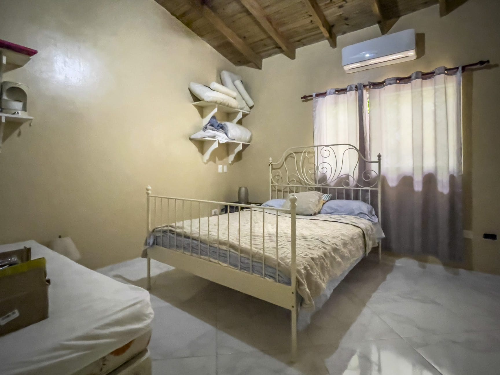 buyDRproperty Bedroom in a For Sale 3 Bedroom Villa with white metal bed frame and window Sosua Real Estate