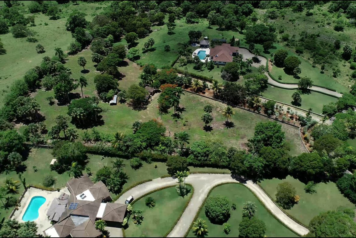 buyDRproperty Aerial view of a beautiful building lot with houses, pool, and landscaping. Sosua Real Estate