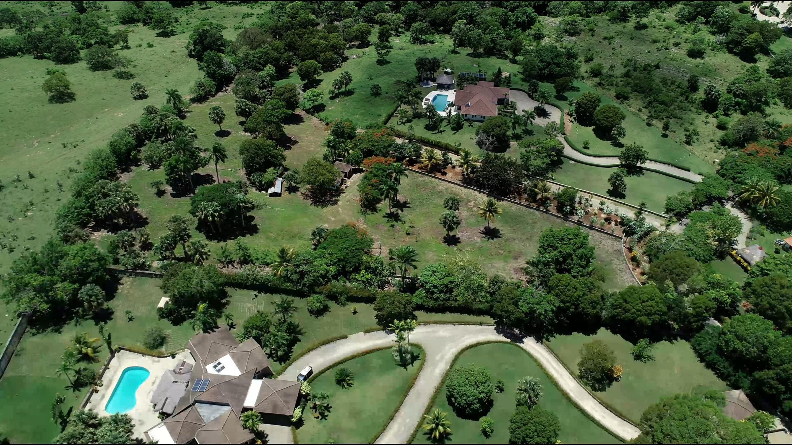 buyDRproperty Aerial view of a beautiful building lot with houses, pool, and landscaping. Sosua Real Estate