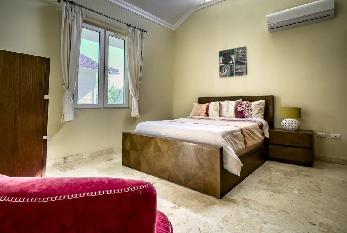 buyDRproperty Stunning 3 Bedroom Condo bedroom interior with bed and window. Sosua Real Estate