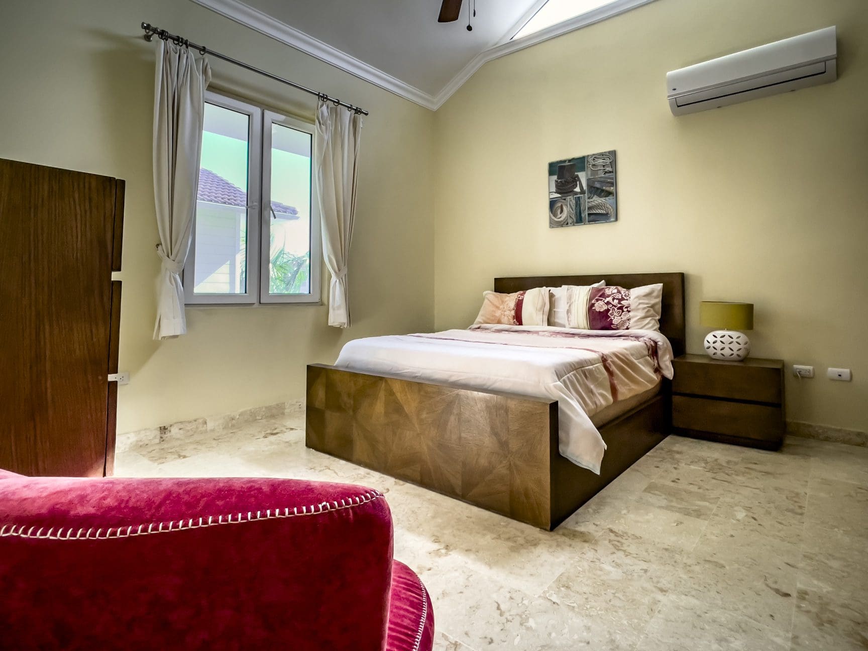 buyDRproperty Stunning 3 Bedroom Condo bedroom interior with bed and window. Sosua Real Estate