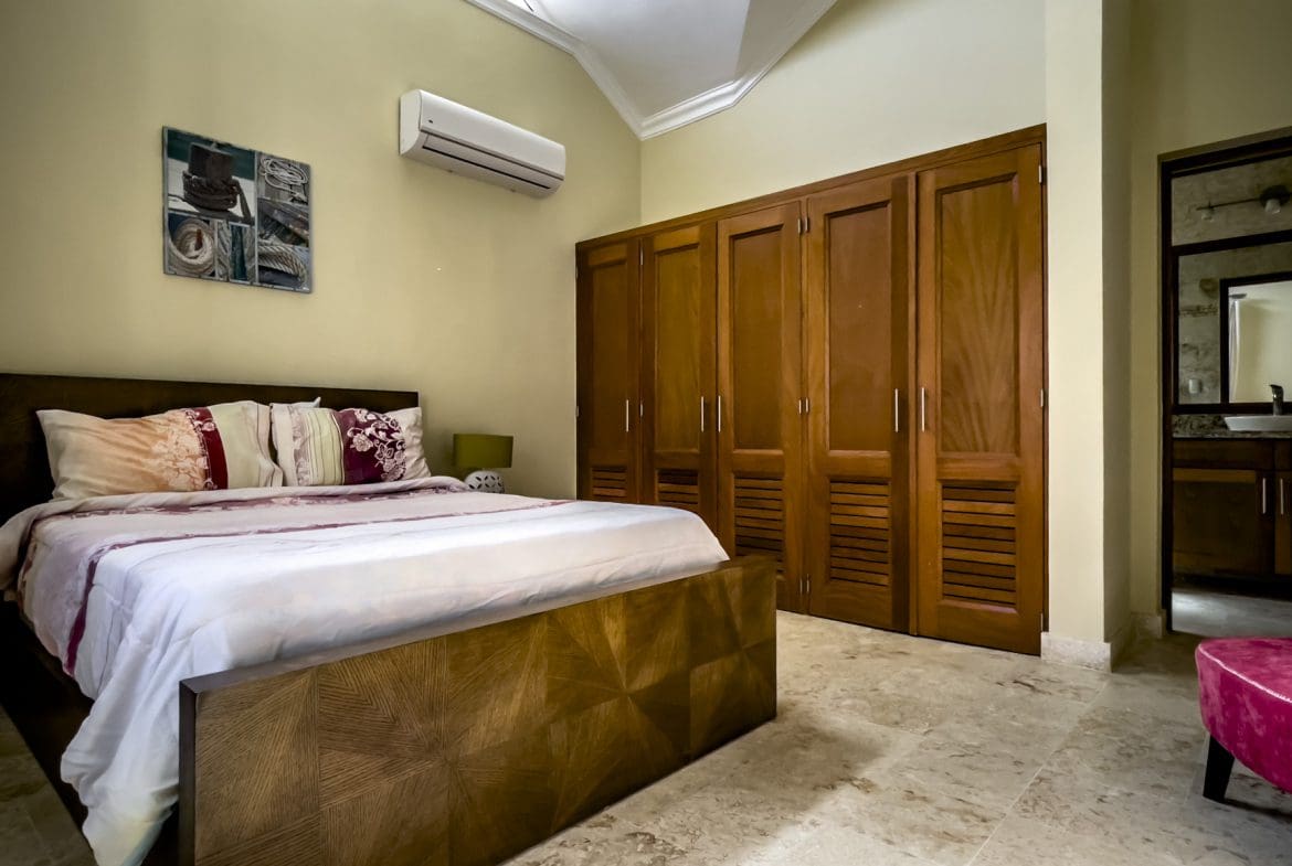 buyDRproperty Stunning 3 bedroom condo bedroom with wooden bed and closet Sosua Real Estate