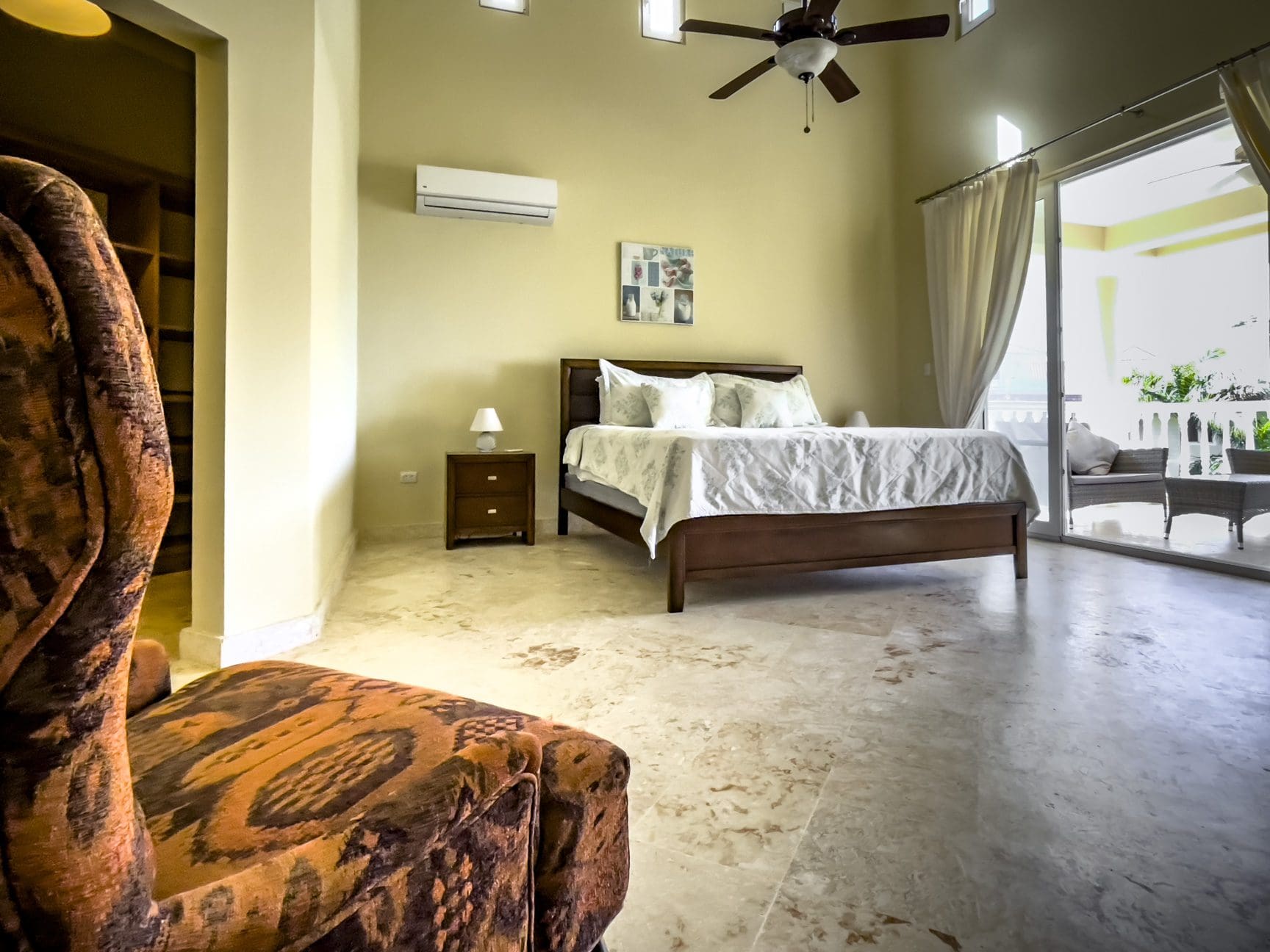 buyDRproperty Luxurious bedroom in a stunning 3 bedroom condo with ocean views. Brown bed, chair. Sosua Real Estate