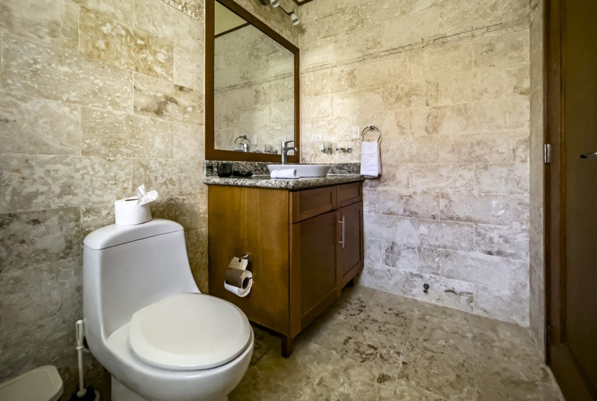 buyDRproperty Bathroom in a stunning 3 bedroom condo with stone tile walls and wood vanity. Sosua Real Estate