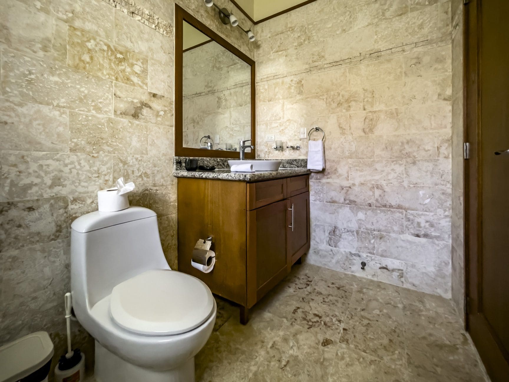 buyDRproperty Bathroom in a stunning 3 bedroom condo with stone tile walls and wood vanity. Sosua Real Estate