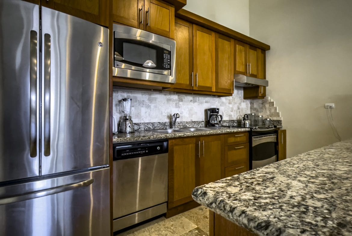 buyDRproperty Stunning 3 bedroom condo kitchen with stainless steel appliances and granite countertops. Sosua Real Estate