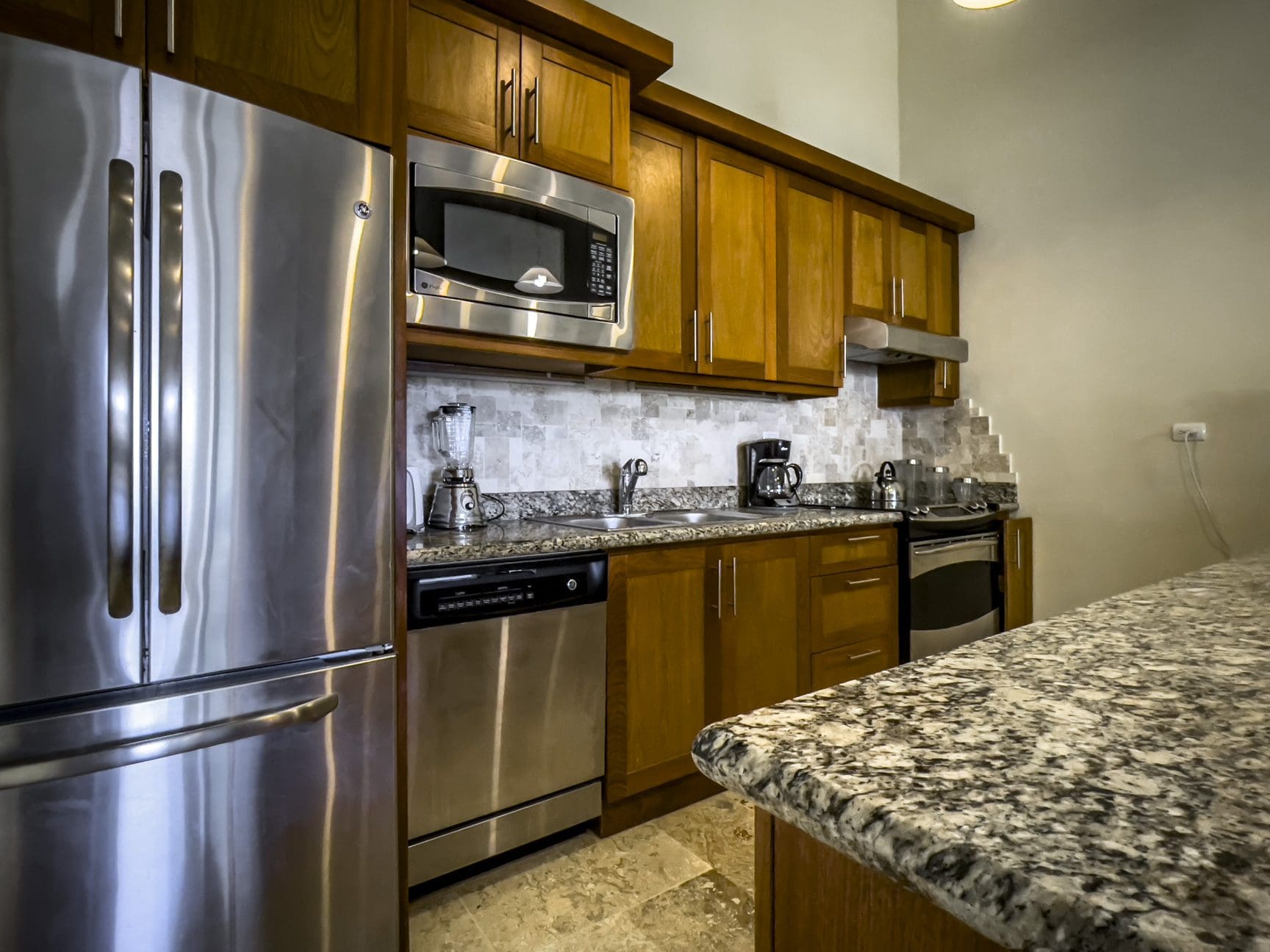 buyDRproperty Stunning 3 bedroom condo kitchen with stainless steel appliances and granite countertops. Sosua Real Estate