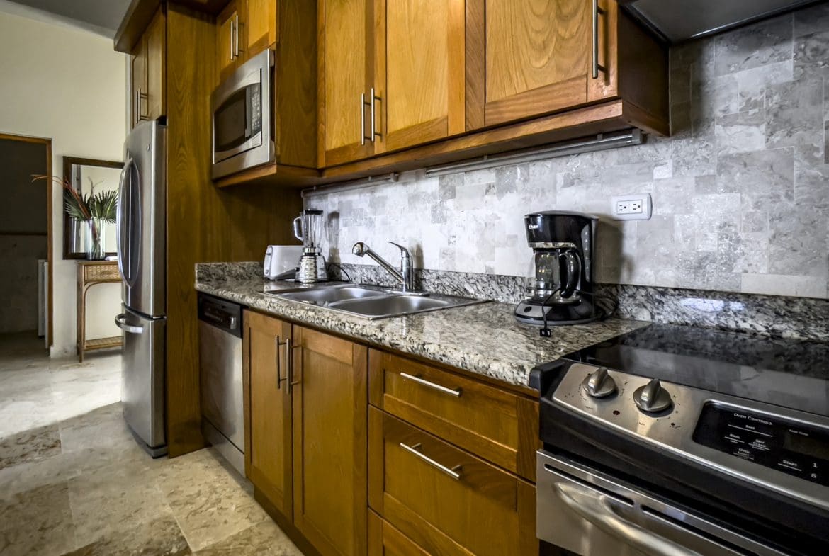 buyDRproperty Kitchen in a stunning 3 bedroom condo with wood cabinets and stainless steel appliances. Sosua Real Estate