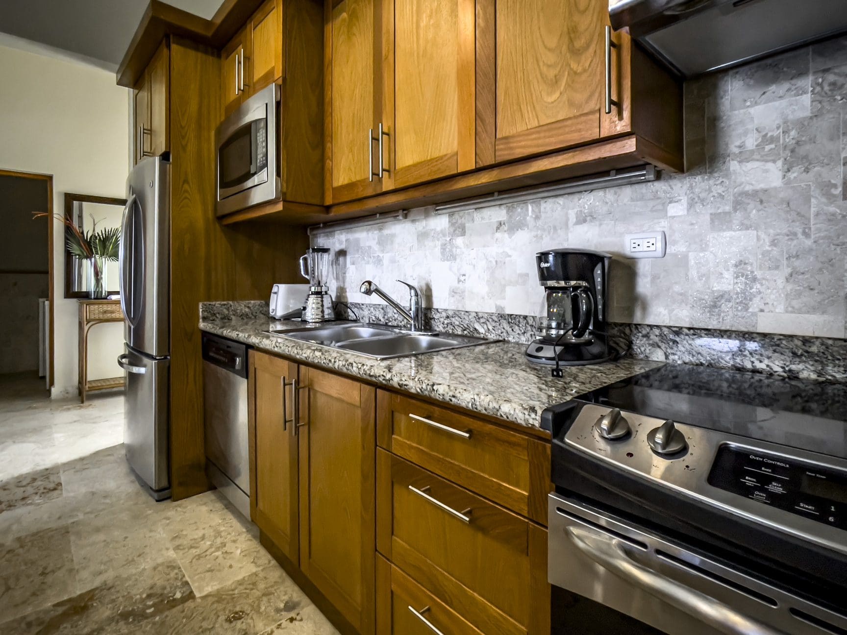 buyDRproperty Kitchen in a stunning 3 bedroom condo with wood cabinets and stainless steel appliances. Sosua Real Estate