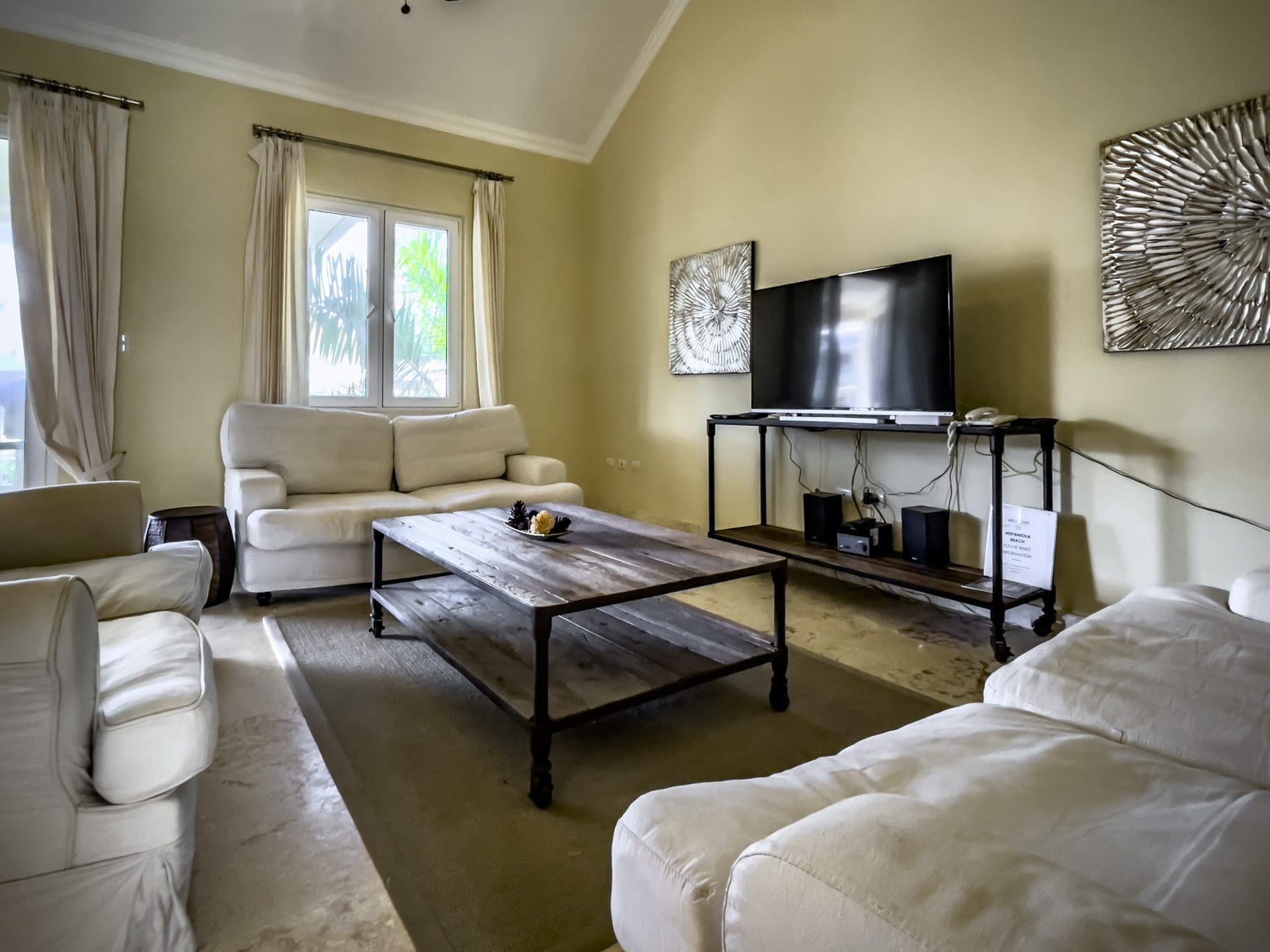 buyDRproperty Living room of a stunning 3 bedroom condo with white sofas, TV, and coffee table. Sosua Real Estate