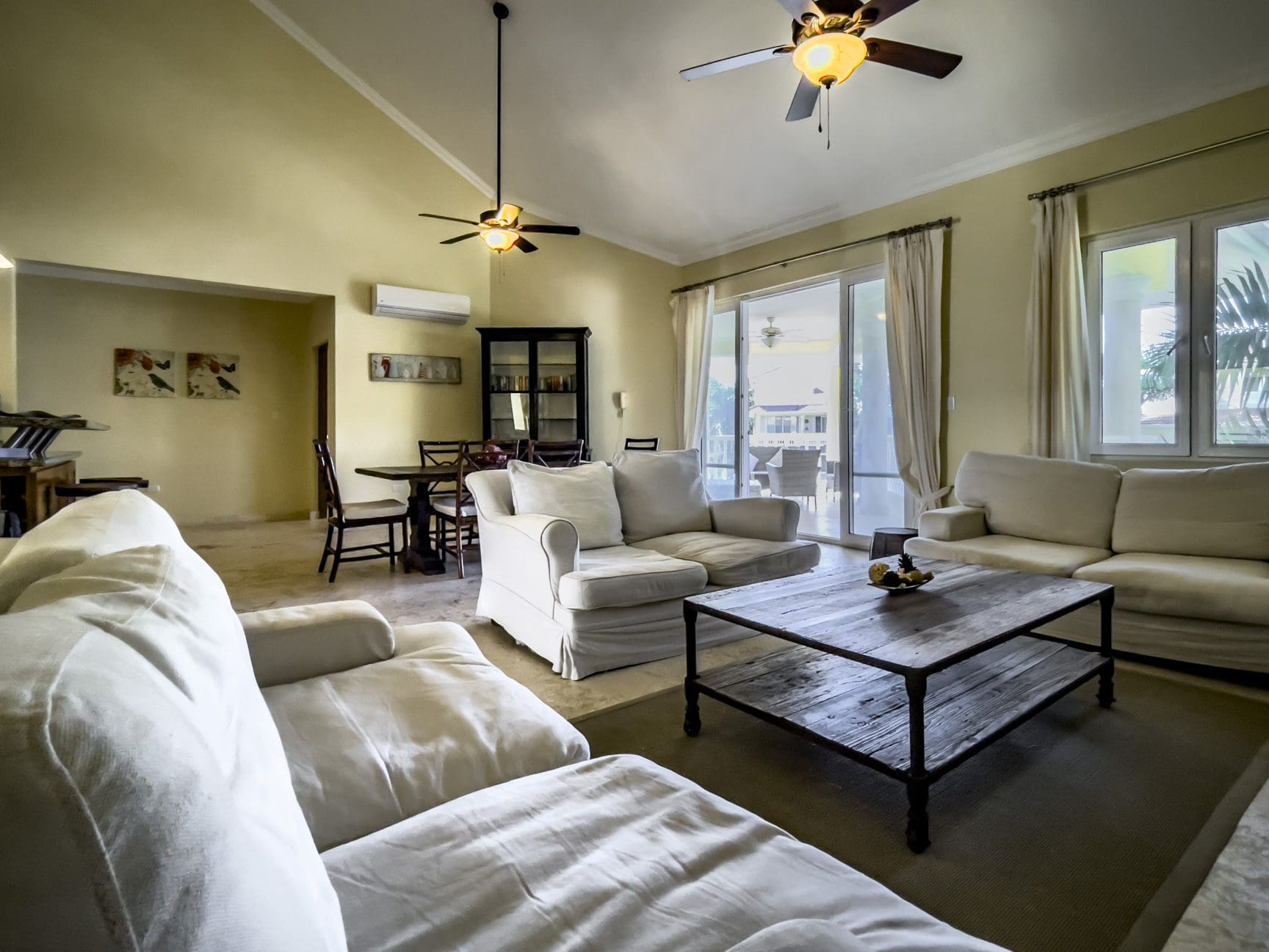 buyDRproperty Living room in a stunning 3 bedroom condo with white couches and rustic coffee table. Sosua Real Estate
