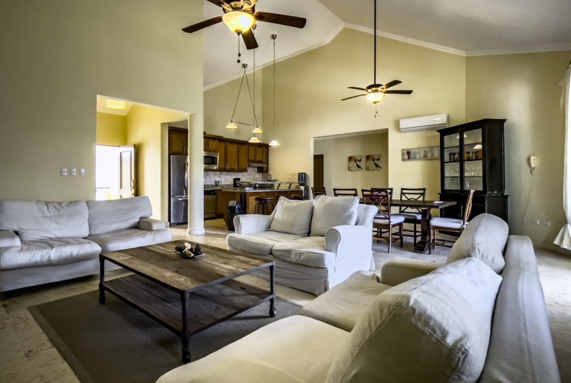 buyDRproperty Spacious living room in a stunning 3 bedroom condo with high ceilings and light-colored furniture. Sosua Real Estate