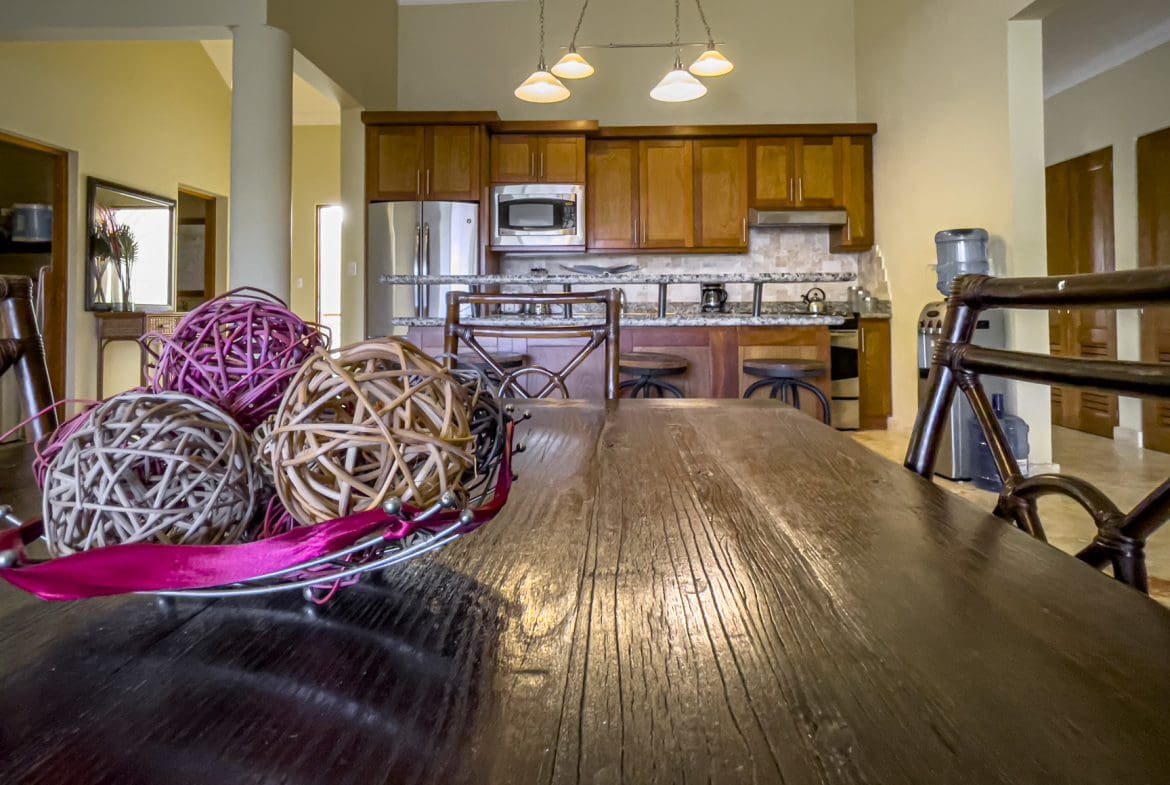 buyDRproperty Stunning 3 Bedroom Condo kitchen with wooden cabinets and decor on the table Sosua Real Estate