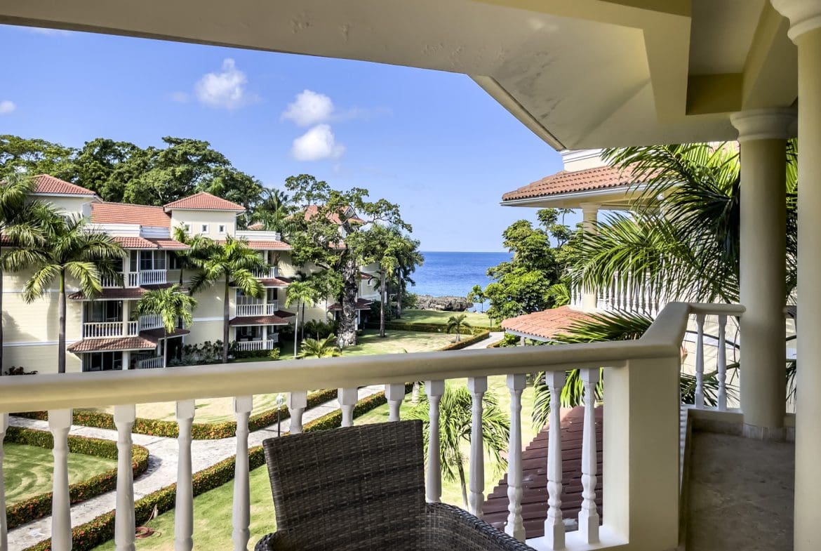 buyDRproperty Stunning 3-bedroom condo balcony overlooking the ocean and lush green grounds. Sosua Real Estate