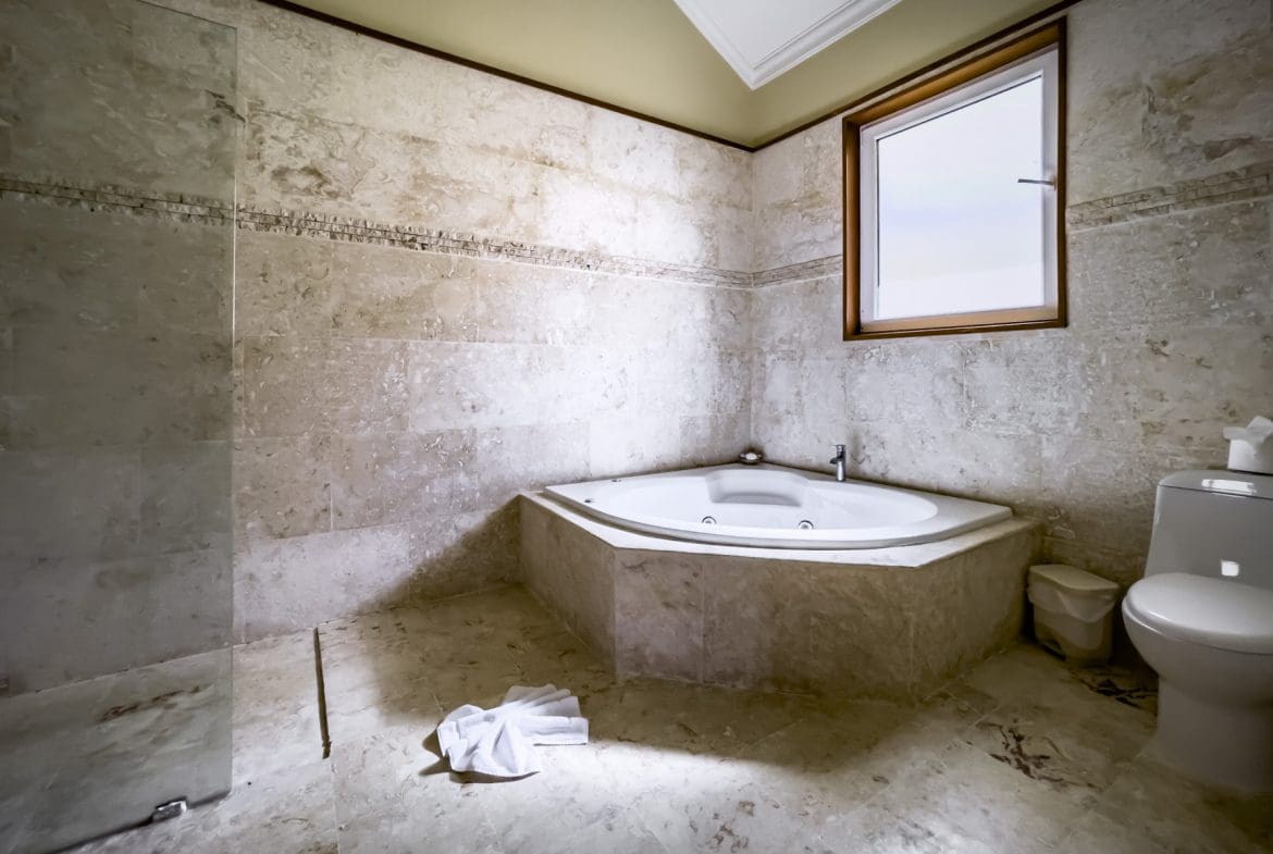 buyDRproperty Luxury bathroom with a corner jacuzzi and stunning stone tile. Part of a Stunning 3 Bedroom Condo. Sosua Real Estate