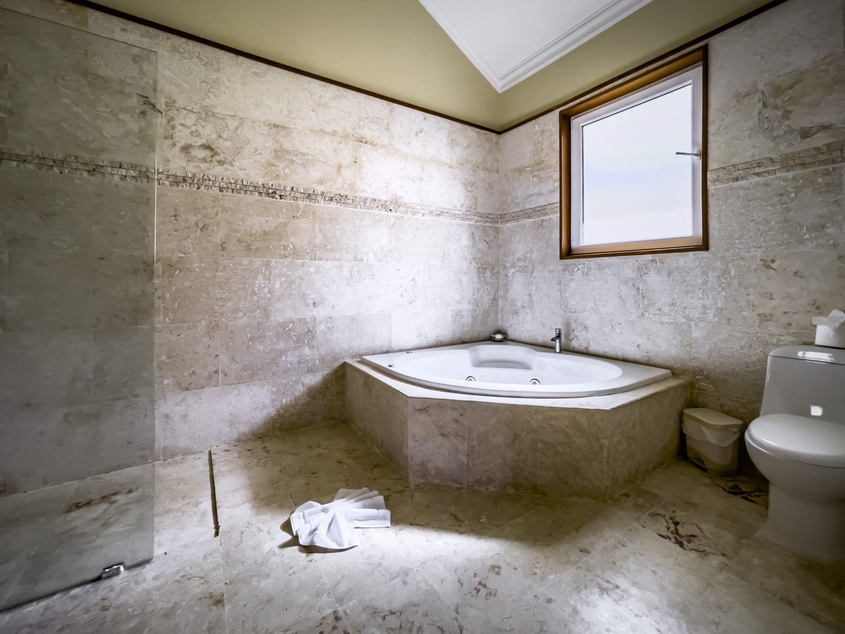 buyDRproperty Luxury bathroom with a corner jacuzzi and stunning stone tile. Part of a Stunning 3 Bedroom Condo. Sosua Real Estate