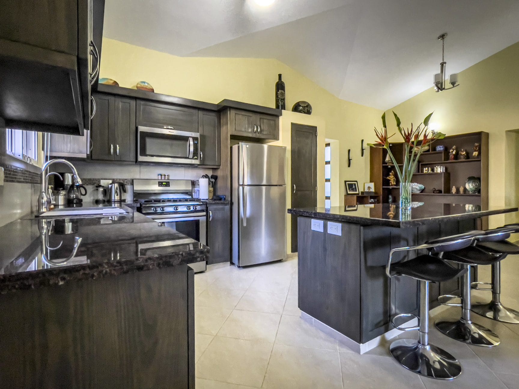 buyDRproperty Modern kitchen in a Stunning 2 Bedroom Villa with dark cabinetry, stainless steel appliances, and a kitchen island. Sosua Real Estate