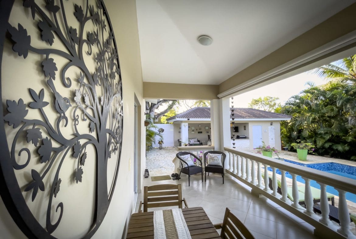 buyDRproperty Outdoor patio view of a stunning 2 bedroom villa with pool and decorative tree art. Sosua Real Estate