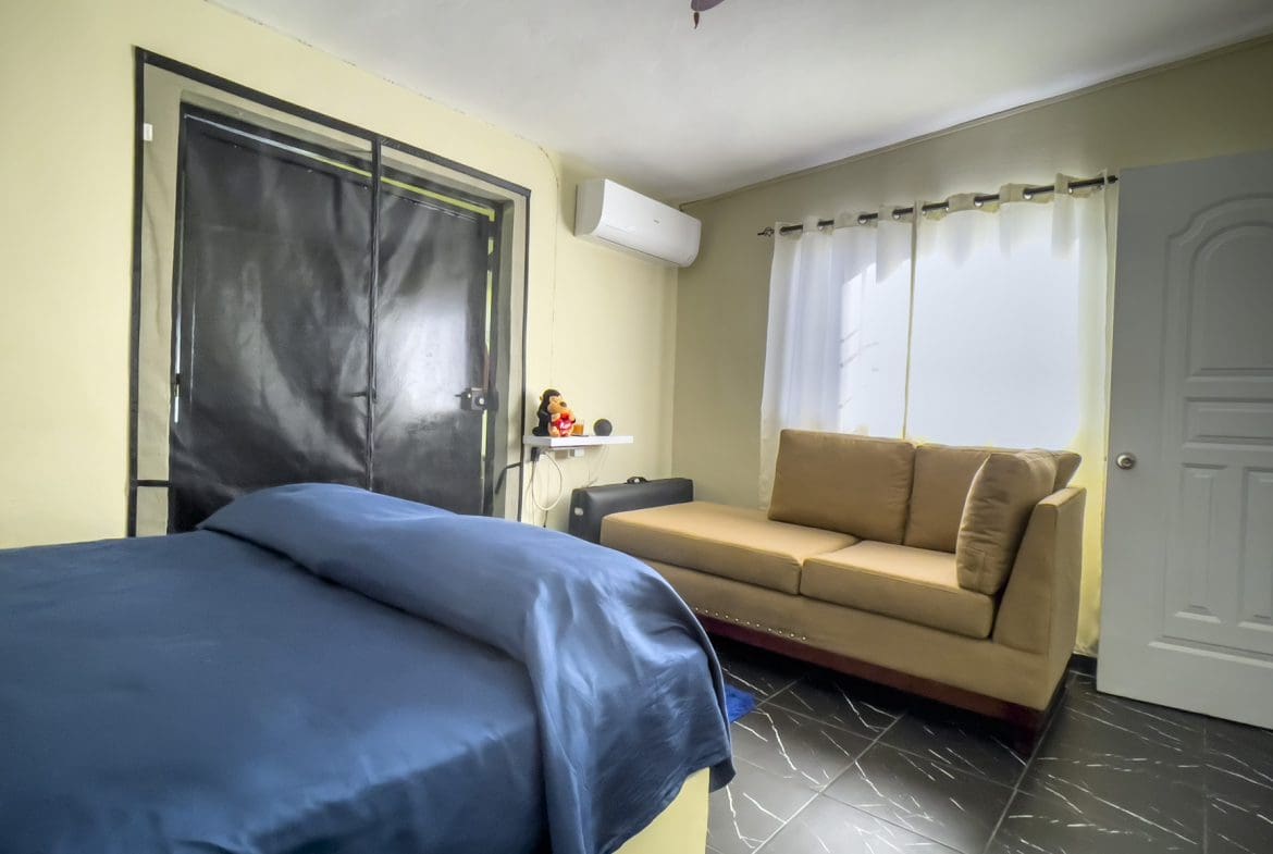buyDRproperty Bedroom with bed, sofa, and window. Smart home for sale! Sosua Real Estate