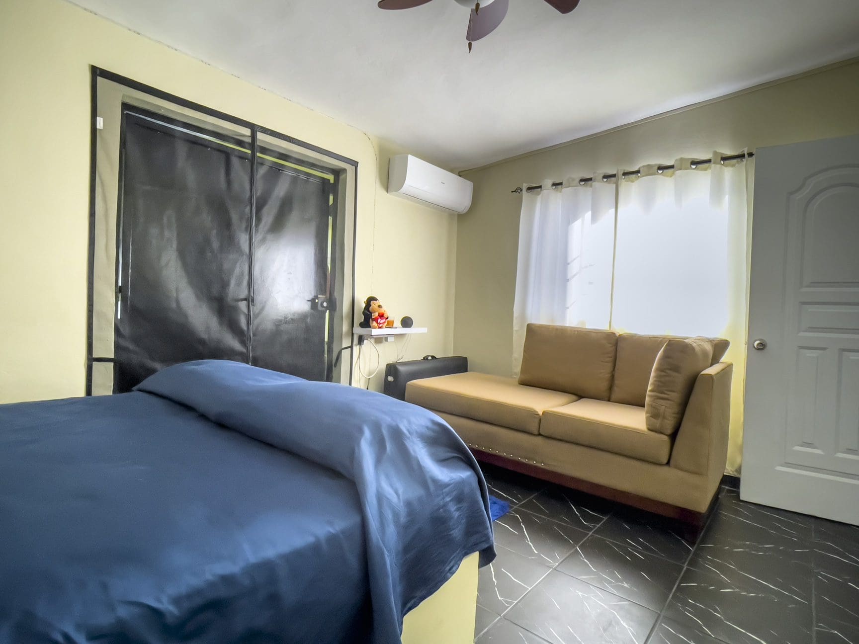 buyDRproperty Bedroom with bed, sofa, and window. Smart home for sale! Sosua Real Estate