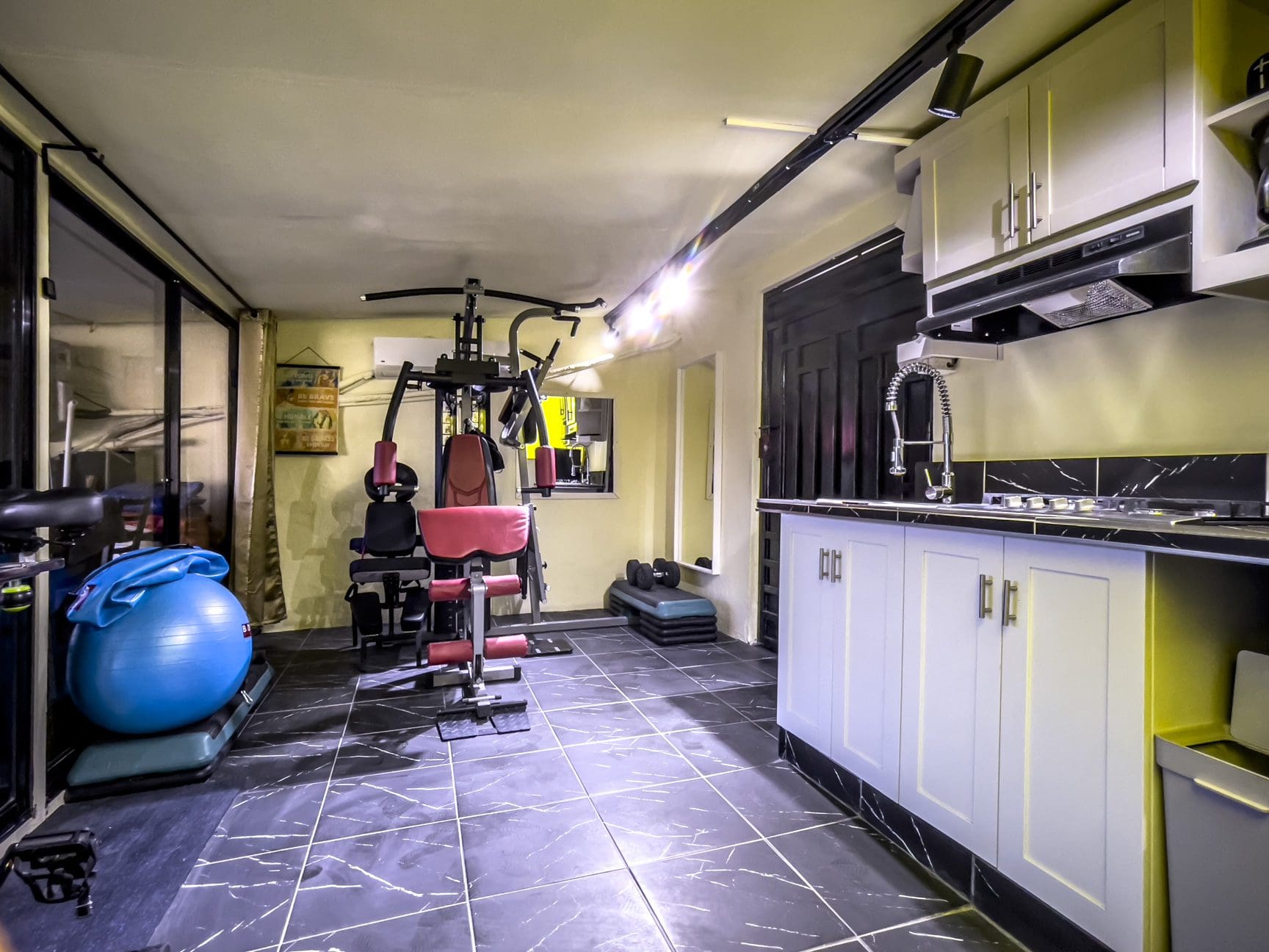 buyDRproperty Home gym with exercise equipment and kitchen, part of a "For Sale! Smart Home". Sosua Real Estate
