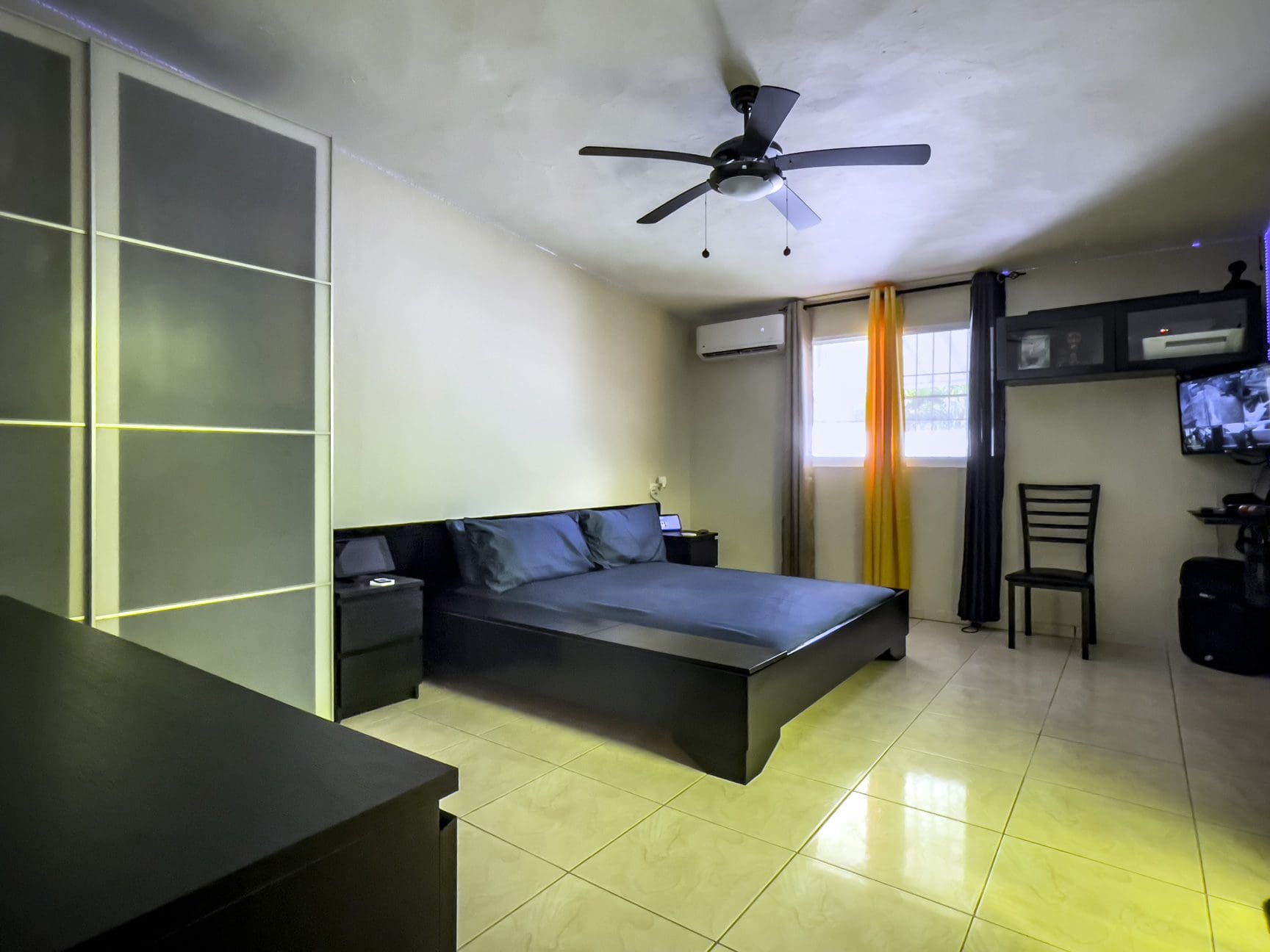buyDRproperty Bedroom in a For Sale! Smart Home, featuring a bed, nightstand, and ceiling fan. Sosua Real Estate