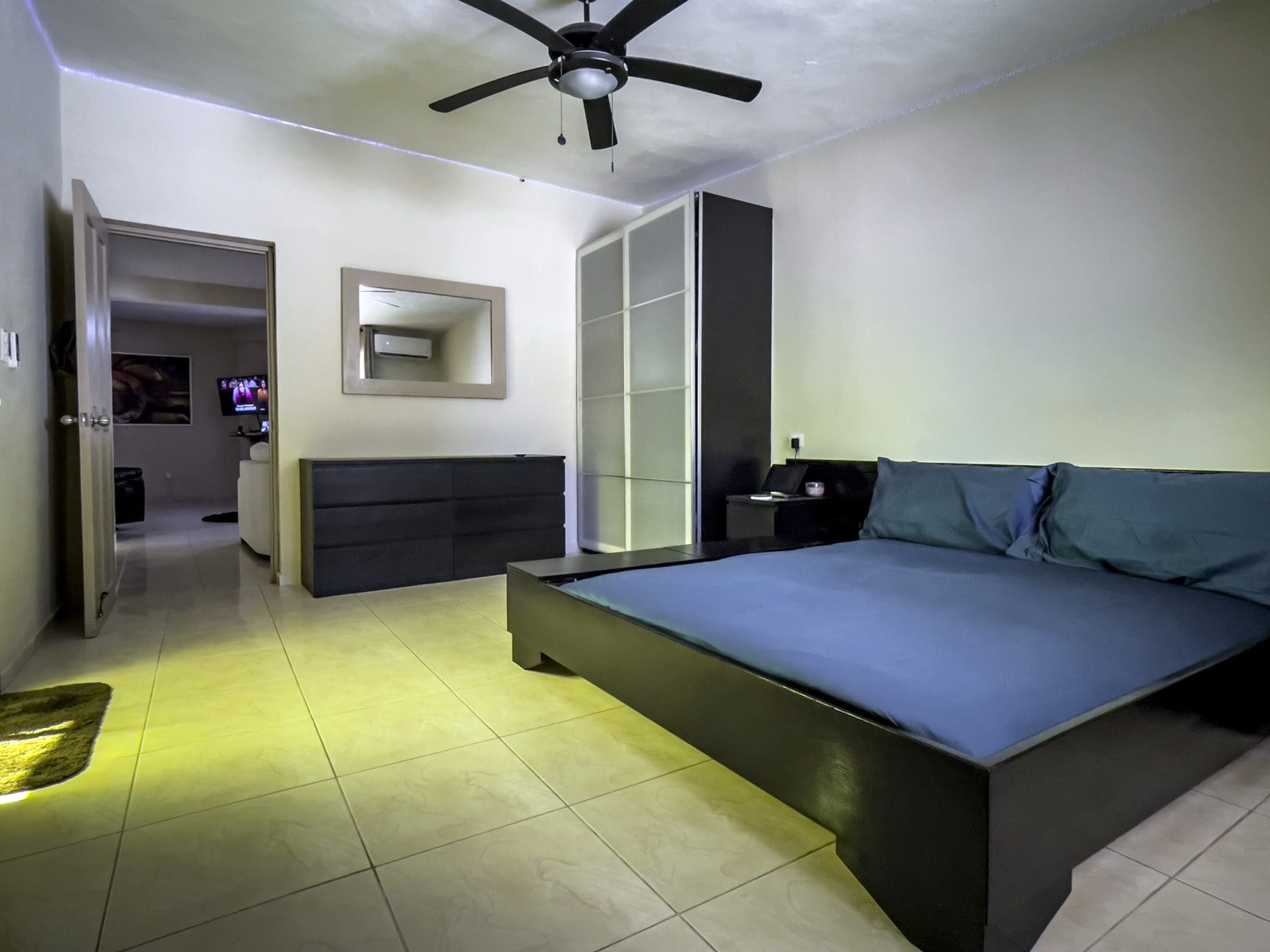 buyDRproperty Modern bedroom with a dark bed frame and blue bedding. For Sale! Smart Home. Sosua Real Estate