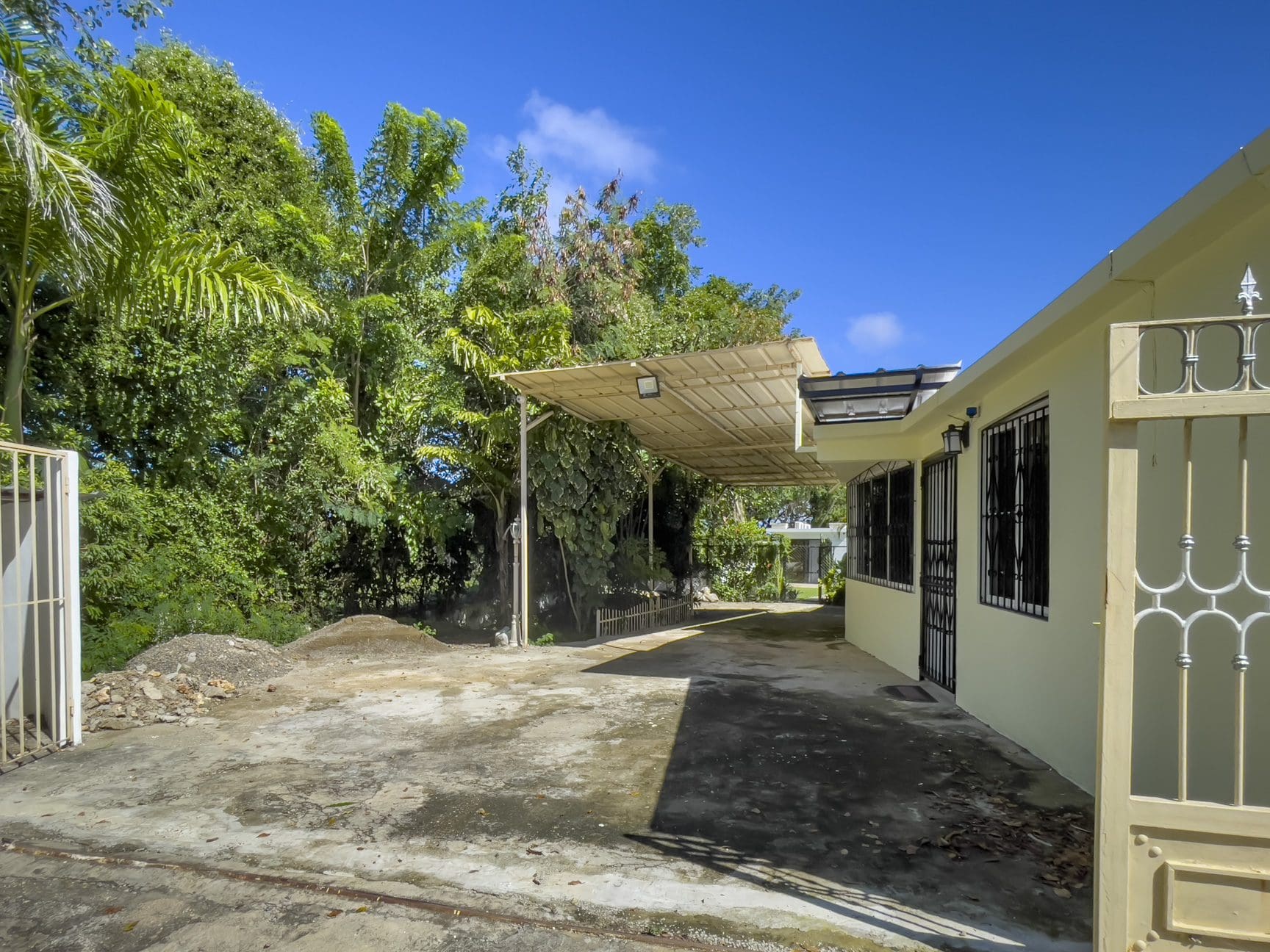 buyDRproperty Exterior view of a home for sale with a carport and driveway. Smart Home. Sosua Real Estate