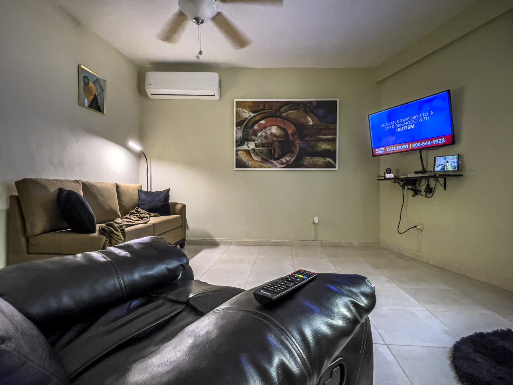 buyDRproperty Living room with TV showing an autism awareness ad. For Sale! Smart Home. Sosua Real Estate
