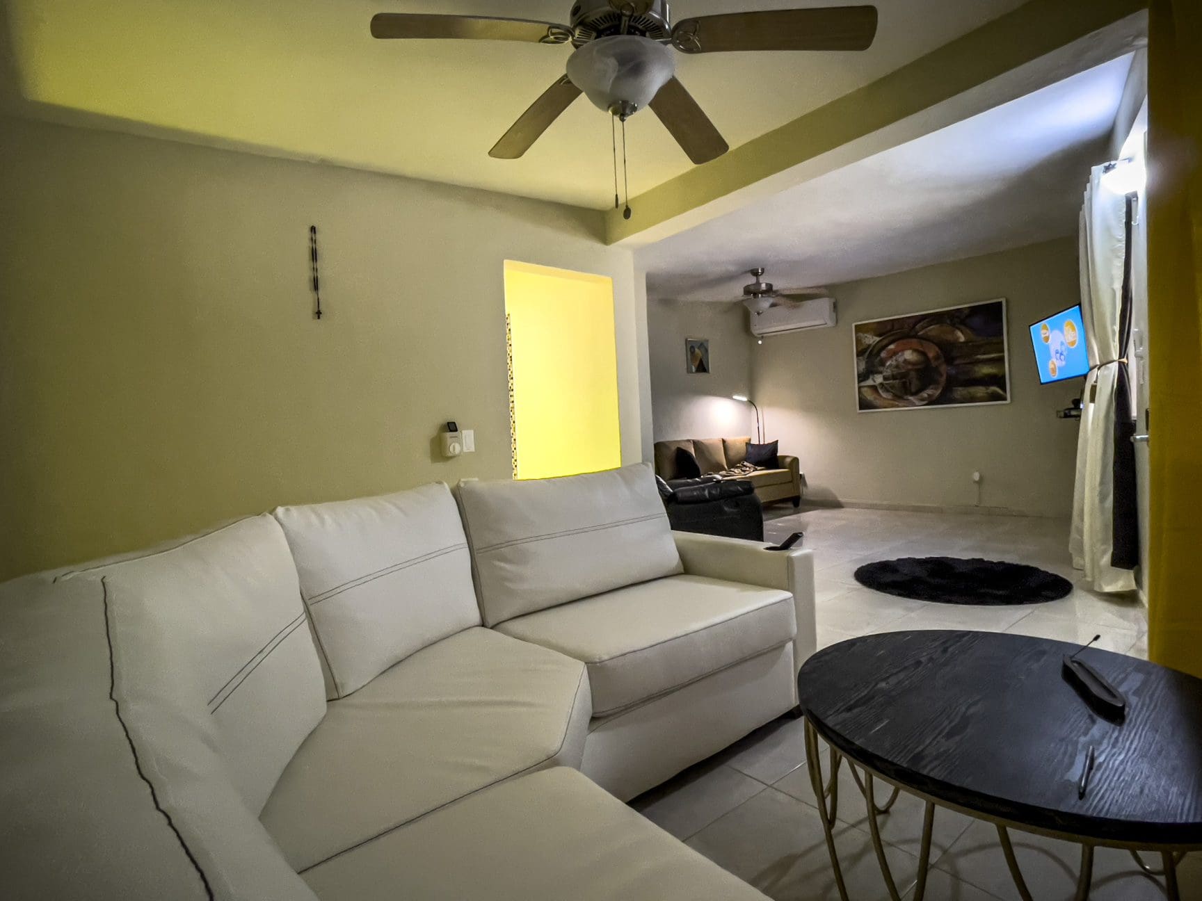 buyDRproperty Living room with white sectional sofa and a smart TV in a For Sale! Smart Home. Sosua Real Estate