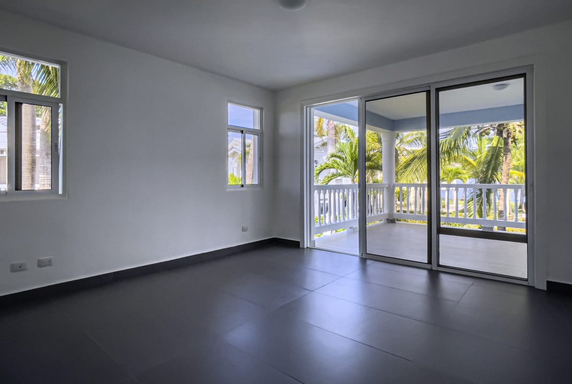 buyDRproperty Empty oceanfront 2 bedroom condo interior with sliding glass doors to balcony Sosua Real Estate