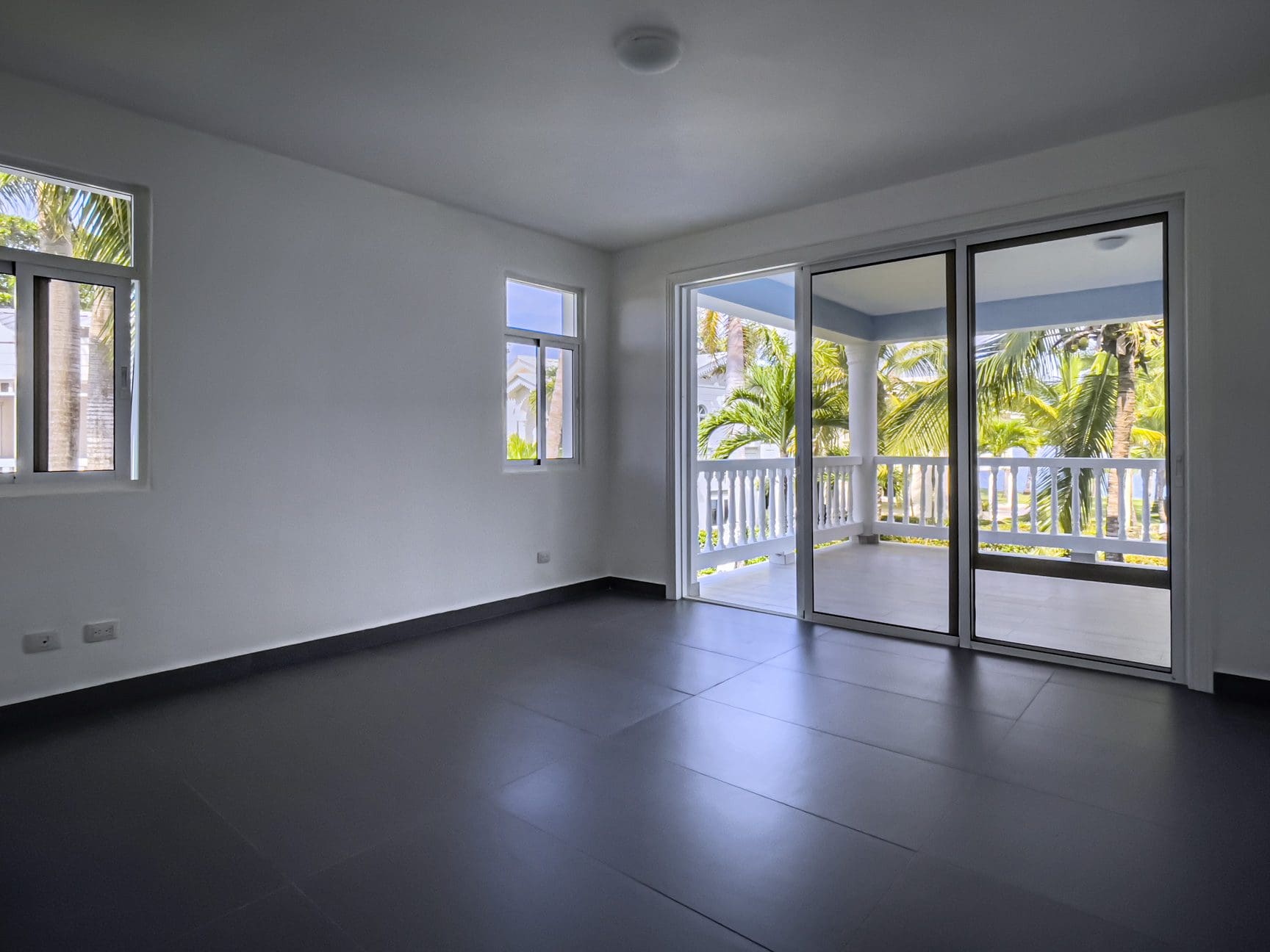 buyDRproperty Empty oceanfront 2 bedroom condo interior with sliding glass doors to balcony Sosua Real Estate