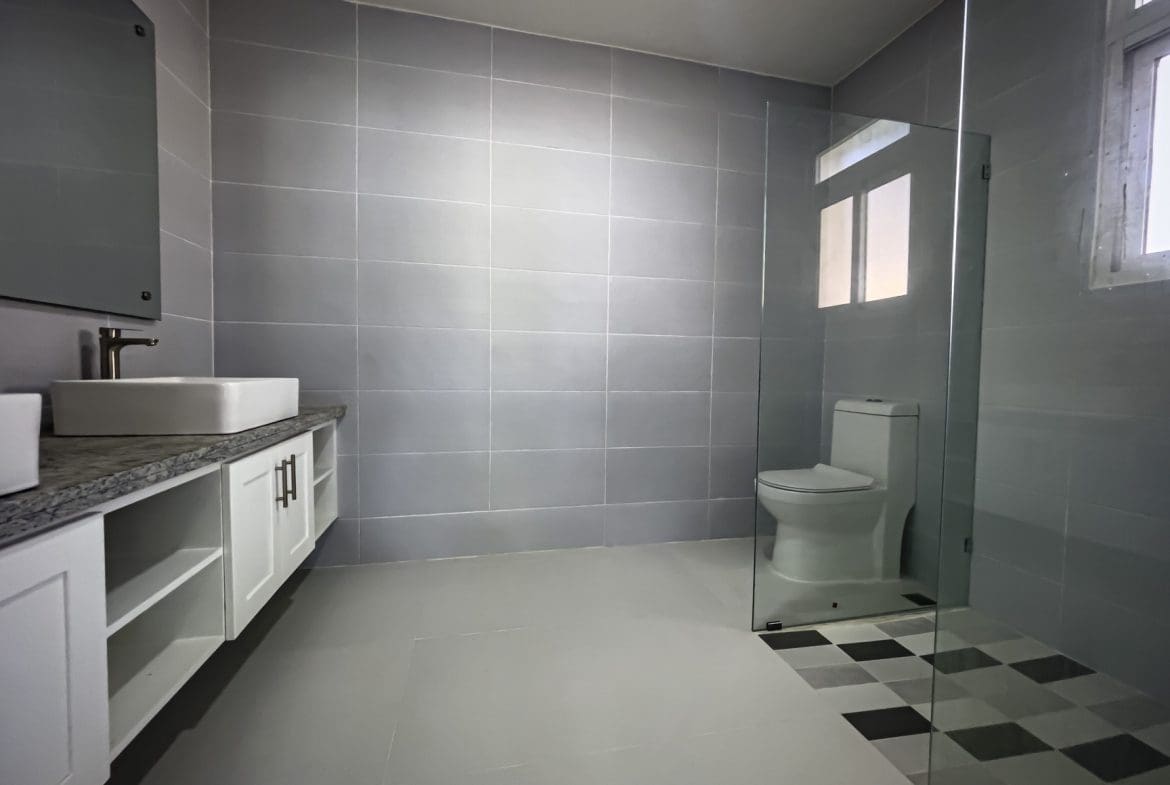 buyDRproperty Modern gray bathroom with white vanity and walk-in shower Sosua Real Estate