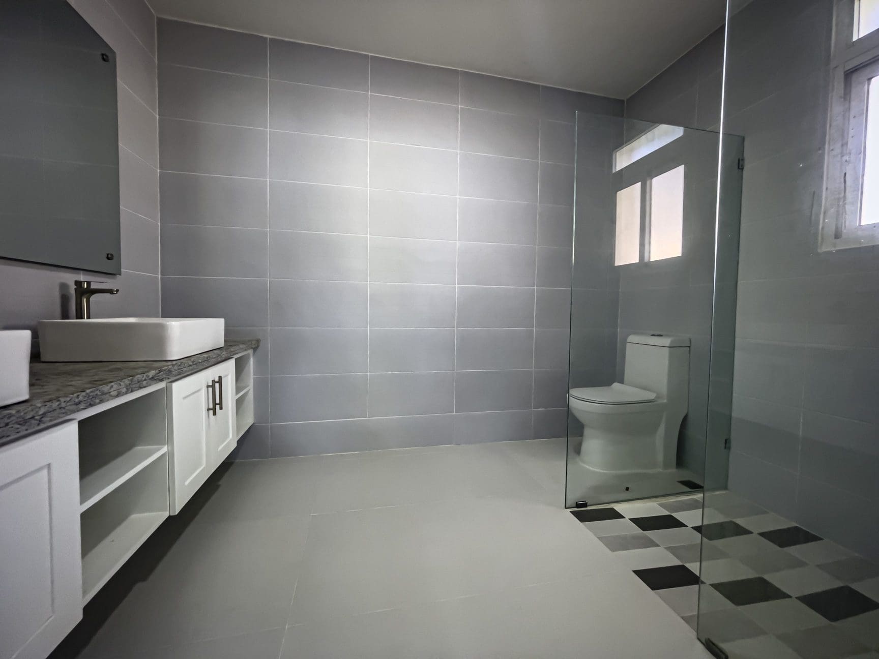 buyDRproperty Modern gray bathroom with white vanity and walk-in shower Sosua Real Estate