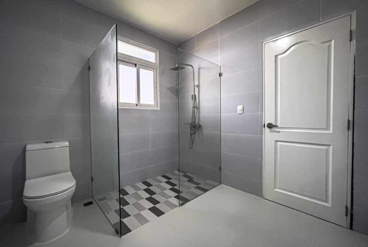 buyDRproperty Modern bathroom with glass shower and patterned tile floor. Sosua Real Estate