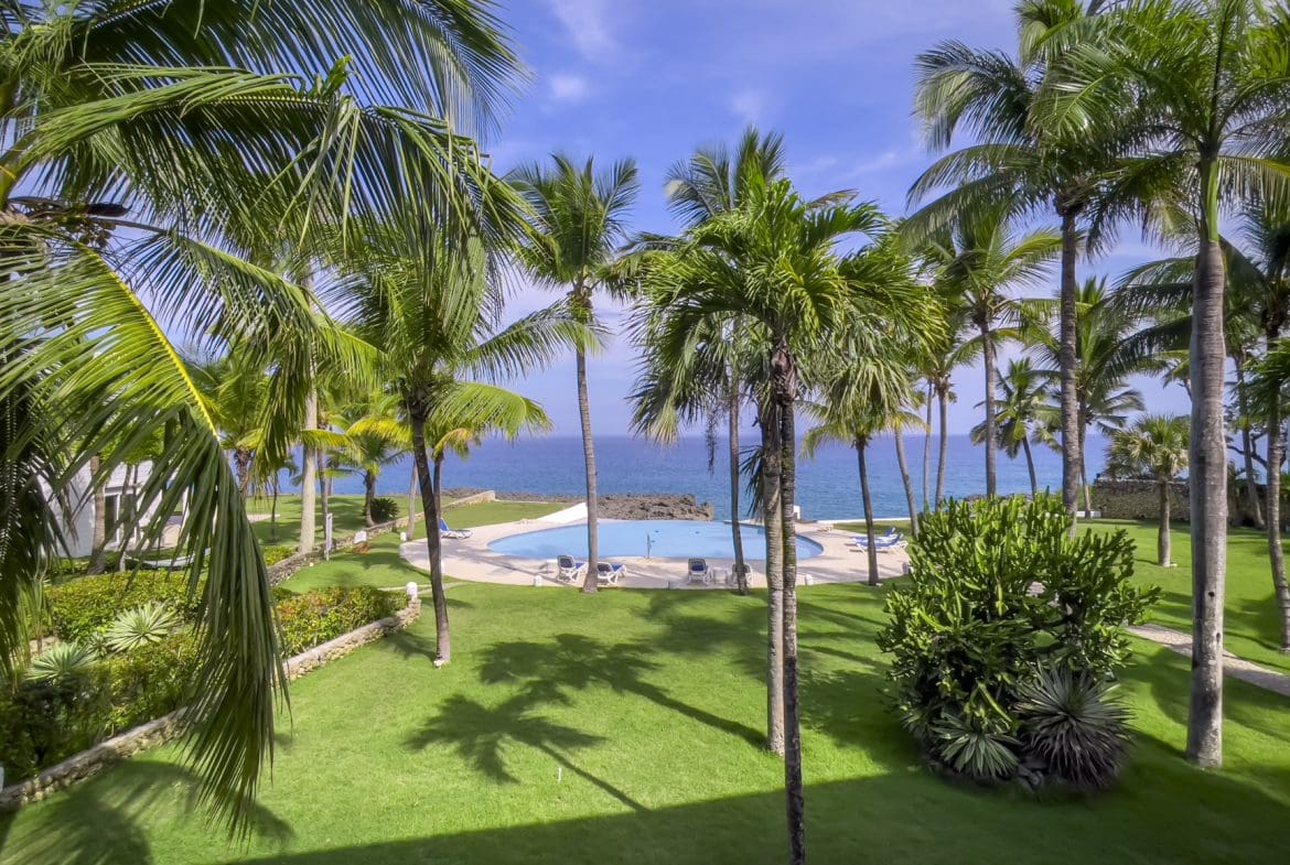 buyDRproperty Oceanfront view of palm trees and a pool at a 2-bedroom condo Sosua Real Estate