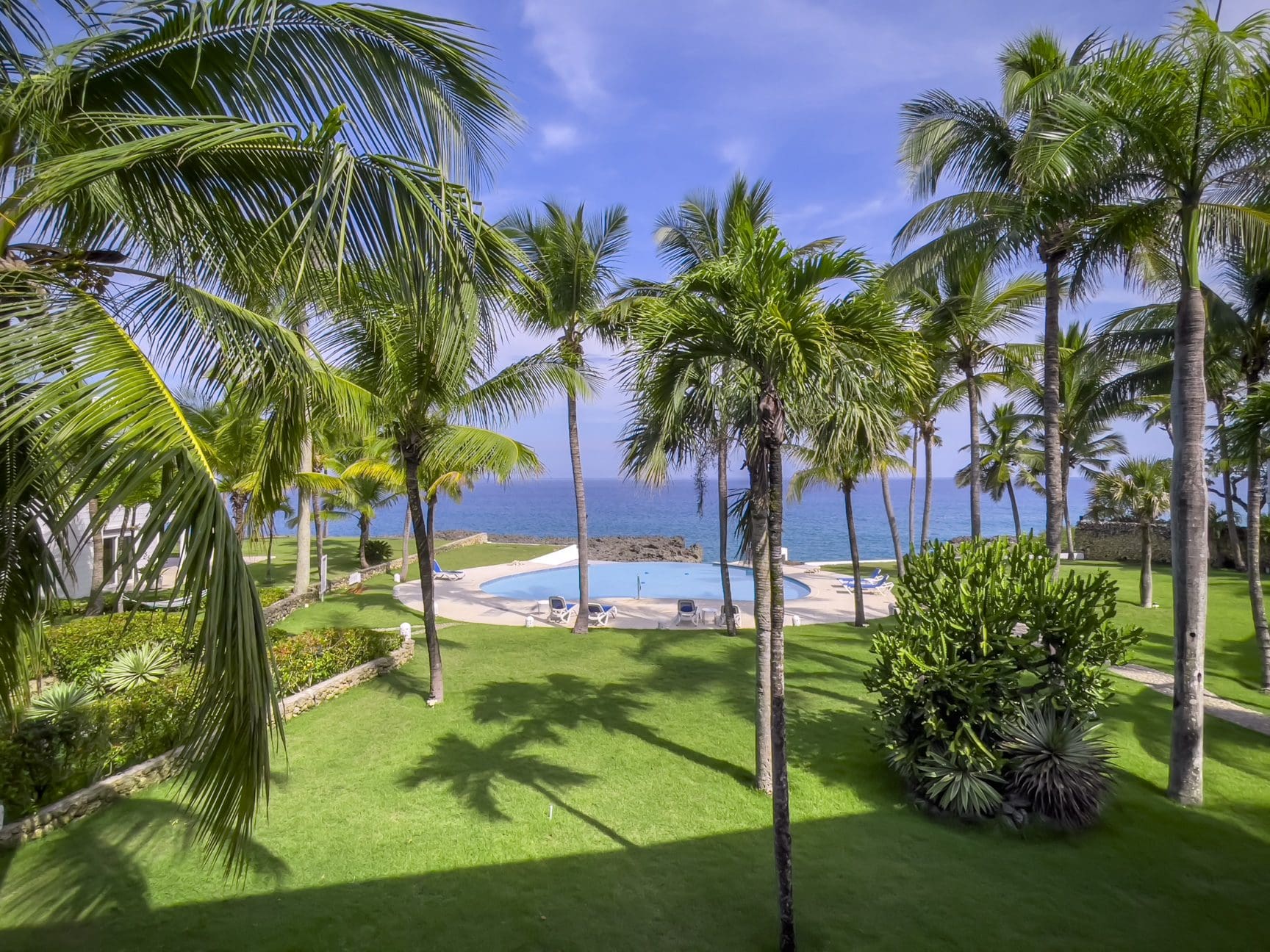 buyDRproperty Oceanfront view of palm trees and a pool at a 2-bedroom condo Sosua Real Estate