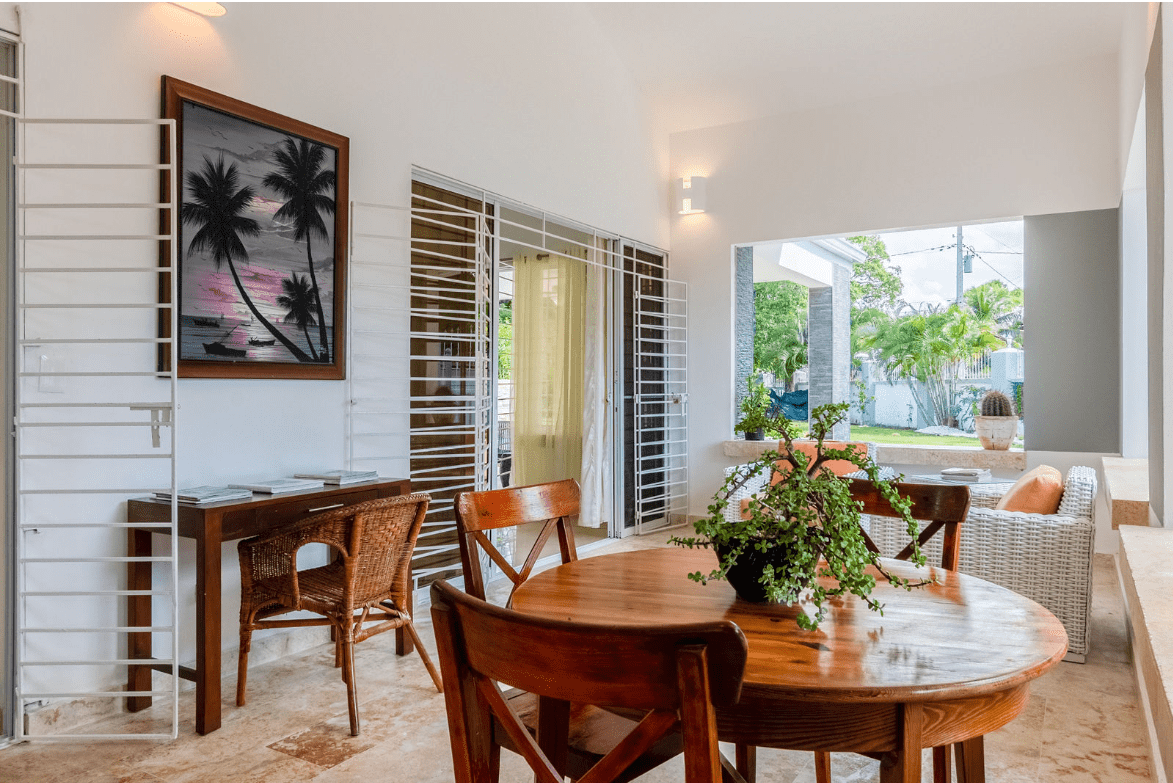 buyDRproperty Outdoor dining area with a round wooden table and chairs in a gorgeous 5 bedroom villa. Sosua Real Estate