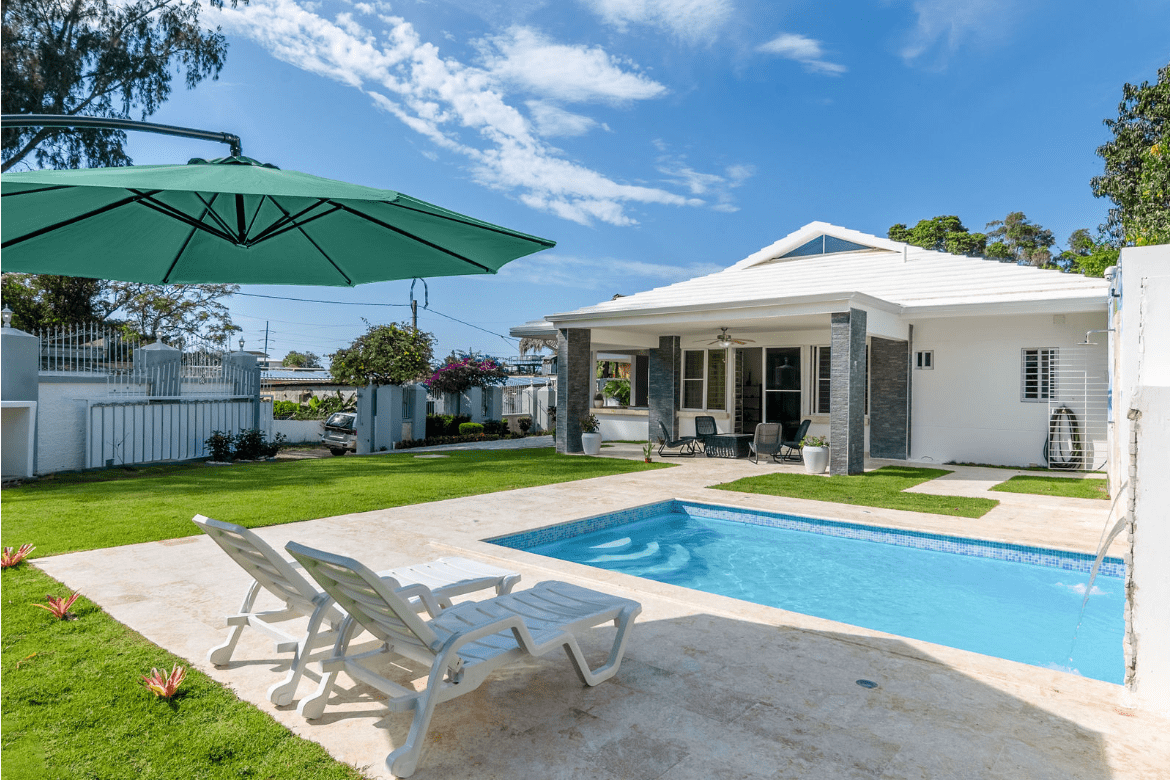 buyDRproperty Gorgeous 5 Bedroom Villa with a pool and lounge chairs on a sunny day Sosua Real Estate
