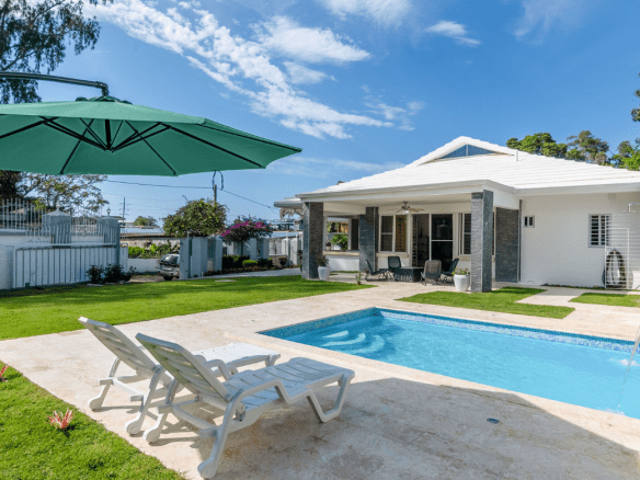 buyDRproperty Gorgeous 5 Bedroom Villa with a pool and lounge chairs on a sunny day Sosua Real Estate