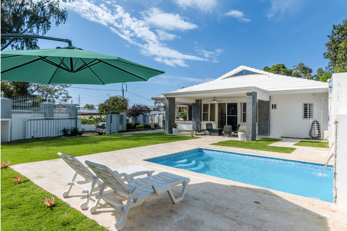 buyDRproperty Gorgeous 5 Bedroom Villa with a pool and lounge chairs on a sunny day Sosua Real Estate
