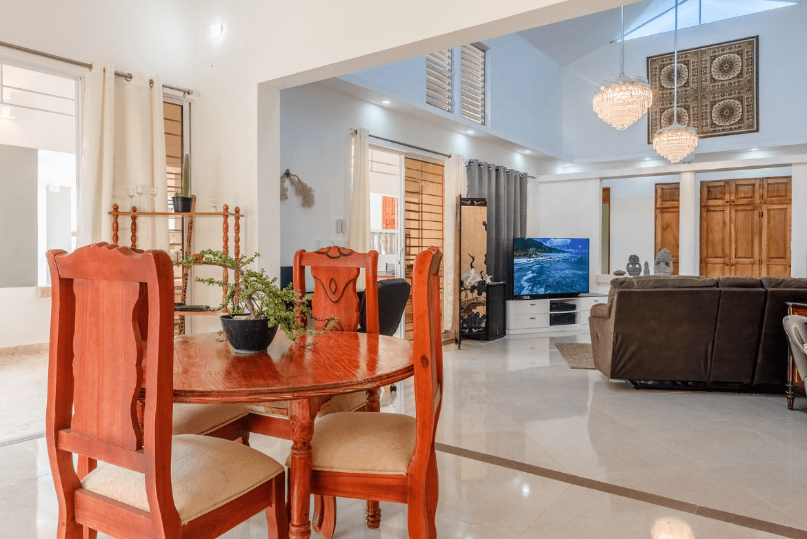 buyDRproperty Dining area of a gorgeous 5 bedroom villa with round wooden table and chairs. Sosua Real Estate
