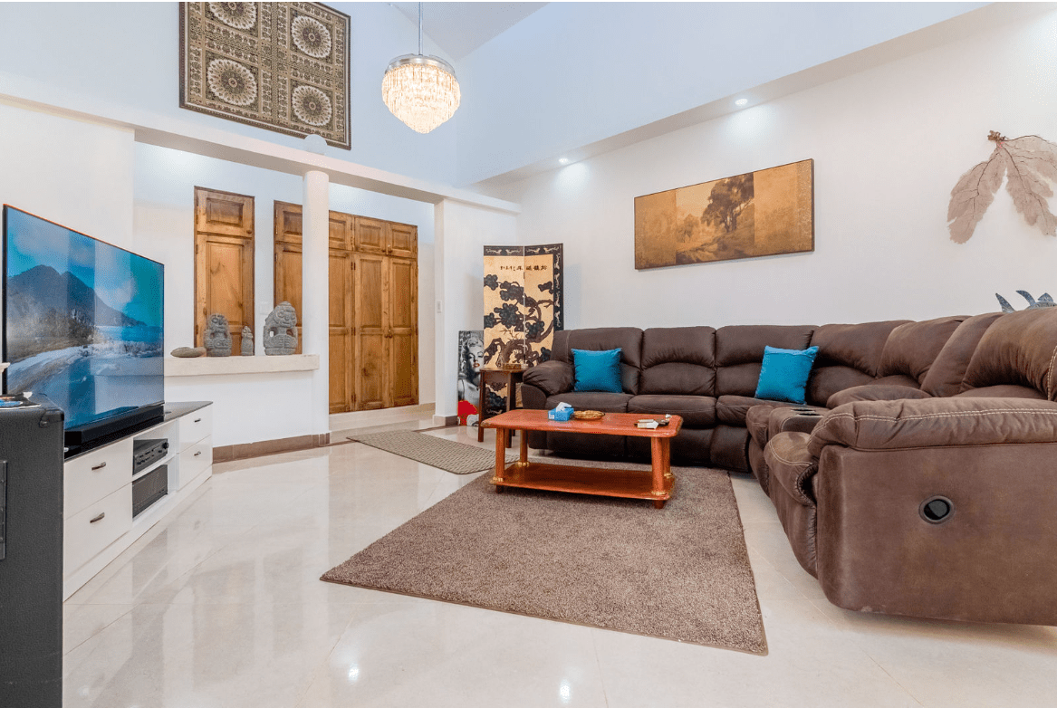 buyDRproperty Spacious living room in a Gorgeous 5 Bedroom Villa with brown leather sectional Sosua Real Estate