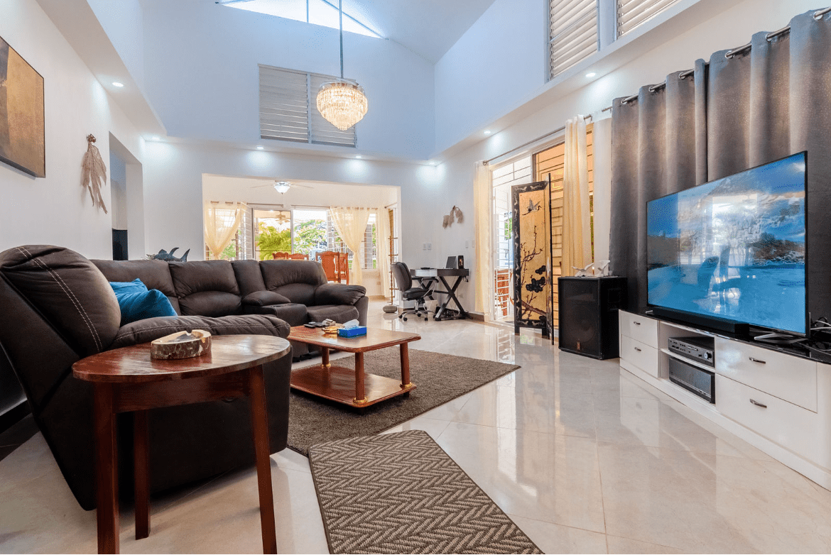 buyDRproperty Spacious living room in a Gorgeous 5 Bedroom Villa with large TV and comfortable seating. Sosua Real Estate