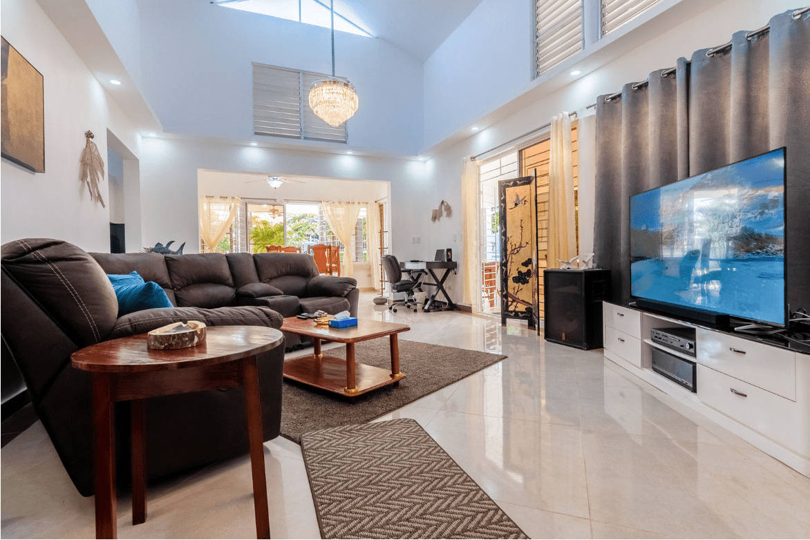 buyDRproperty Spacious living room in a Gorgeous 5 Bedroom Villa with large TV and comfortable seating. Sosua Real Estate