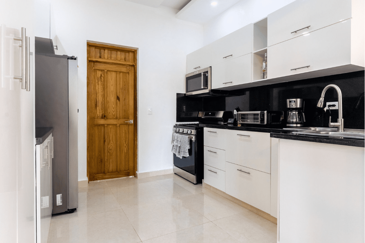 buyDRproperty Modern kitchen in a gorgeous 5 bedroom villa with white cabinets and stainless steel appliances. Sosua Real Estate
